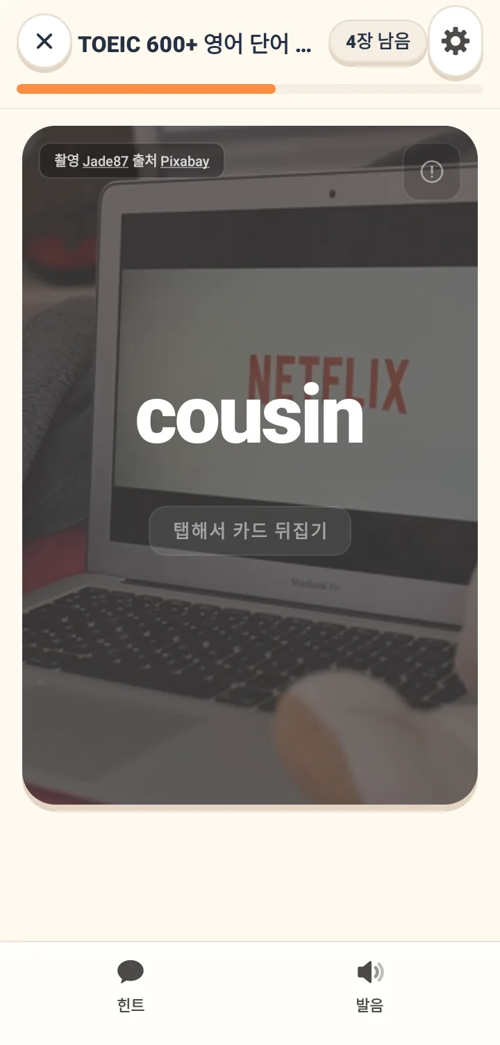 단어 카드 앞면 화면. 상황 사진 배경의 중앙에 커다란 영단어가 있고 그 아래에 탭해서 뒤집으라는 힌트가 있으며, 맨 위에는 플랜 이름과 남은 카드 수가 표시되어 있음.